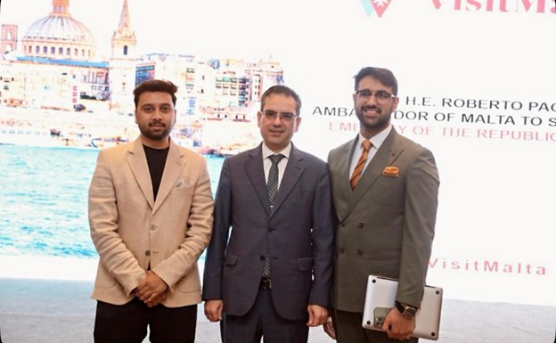 Three men dressed in formal suits, standing closely together with neutral expressions.